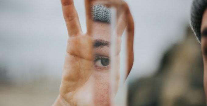 Close up picture of a man looking at himself in a mirror. 