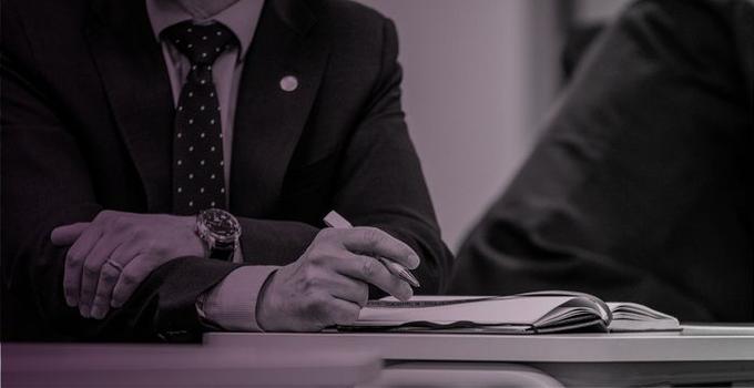 Händer på bord som antecknar, rosatonad bild.