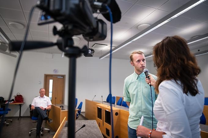 Student som spelar utrikesminister blir intervjuad och filmad för att öva på att svara på frågor från journalister. 