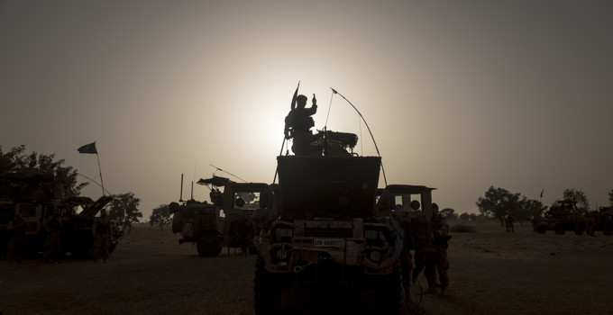 Militärer i militära fordon i gryningen.