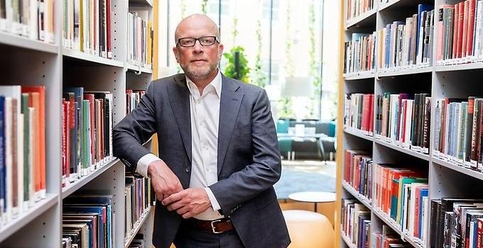 Jann Kleffner står mellan två bokhyllor i Anna Lindh-biblioteket. 