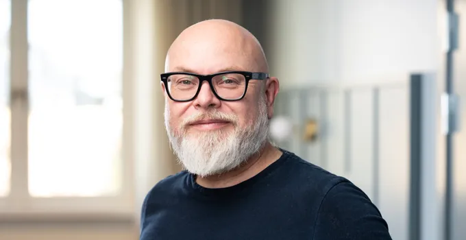 En man med vitt skägg som bär glasögon.