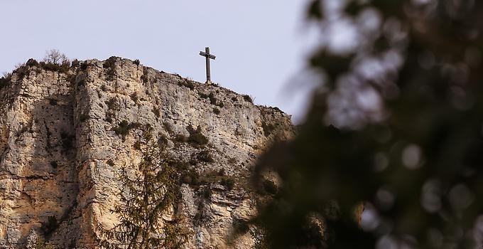 Kors som står högst upp på en klippa. 