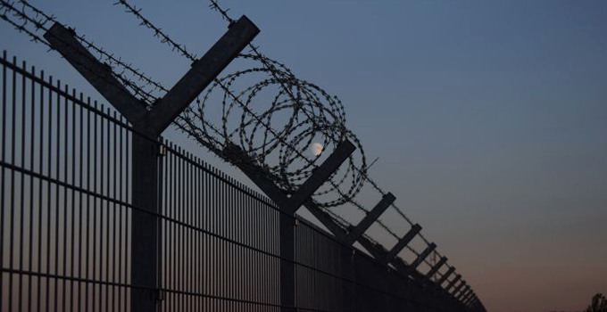 Barbed wire on top of a fence.