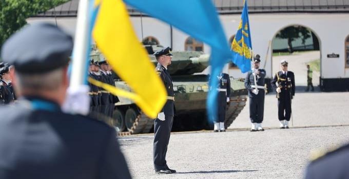 Svenska flaggan i förgrunden vid avslutningen av Officersprogrammet i juli 2021.