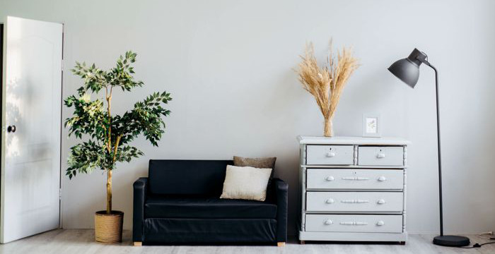 Lägenhetsinteriör, soffa, byrå och lampa.