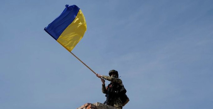 A Military Man Raises The Ukrainian Flag Over A City Liberated From The Enemy