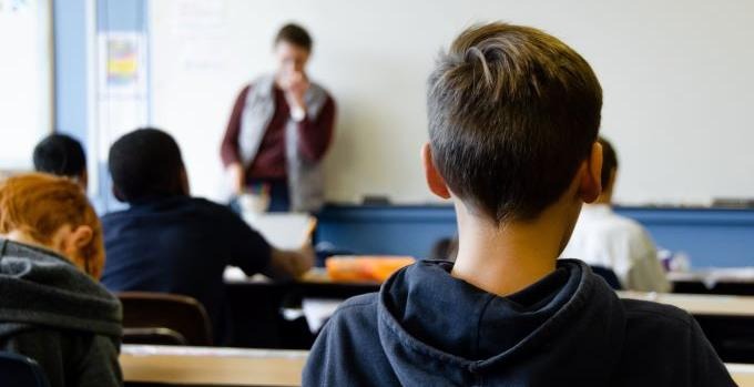 Elever sitter i sina bänkar i ett klassrum.