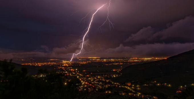 Blixt på en natthimmel över en stad.