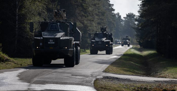 Militära fordon på en väg.