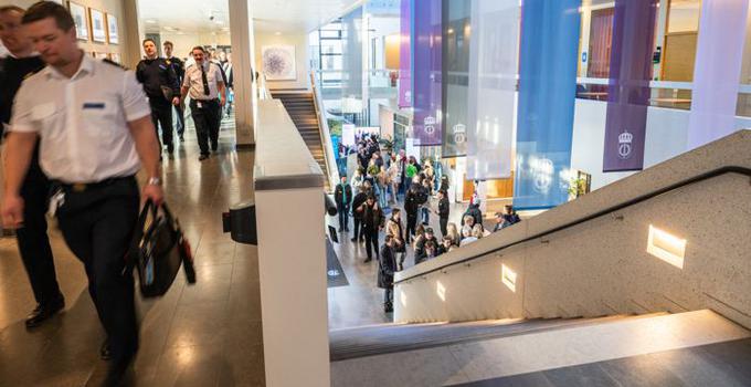 Personer som går i korridor bredvid en trappa. 