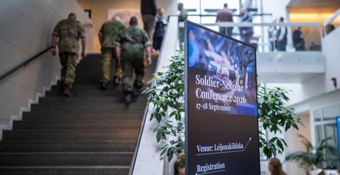 FHS entré med skylt till konferensen och militärer i bakgrunden.