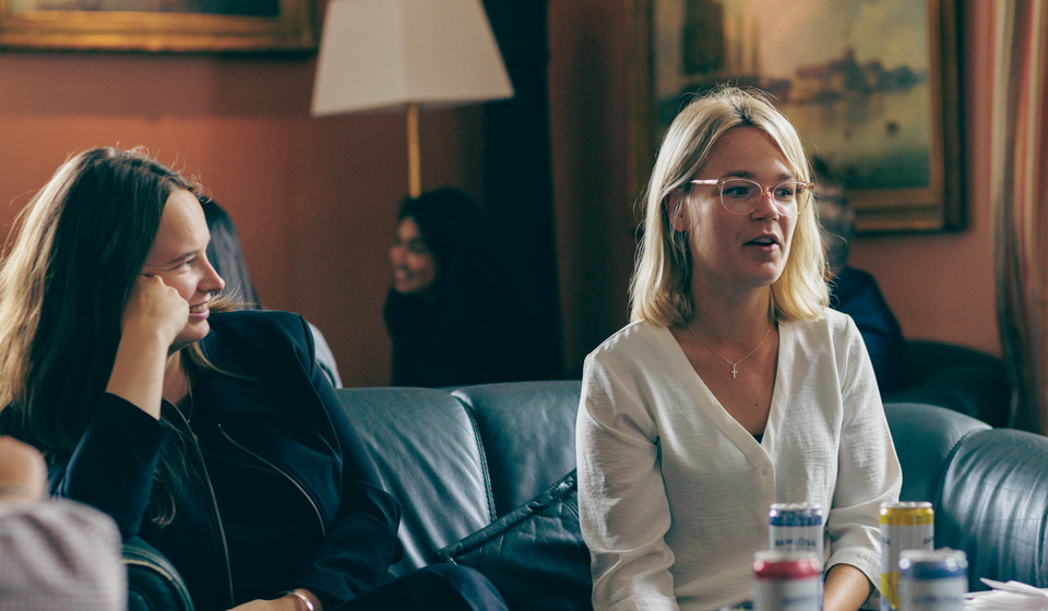 Två kvinnliga studenter sitter i en av sofforna i Mässen.