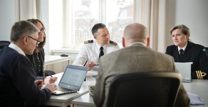 Medarbetare vid Försvarshögskolan diskuterar runt ett bord.