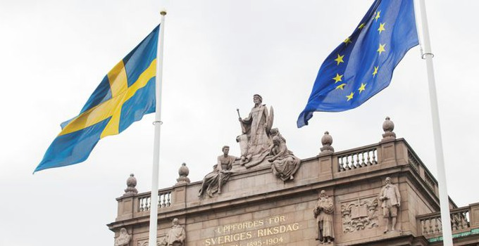 Maj 2014. Östra riksdagshuset. Vår. Försommar. Svenska flaggan och EU-flaggan är hissade. Moder Svea.