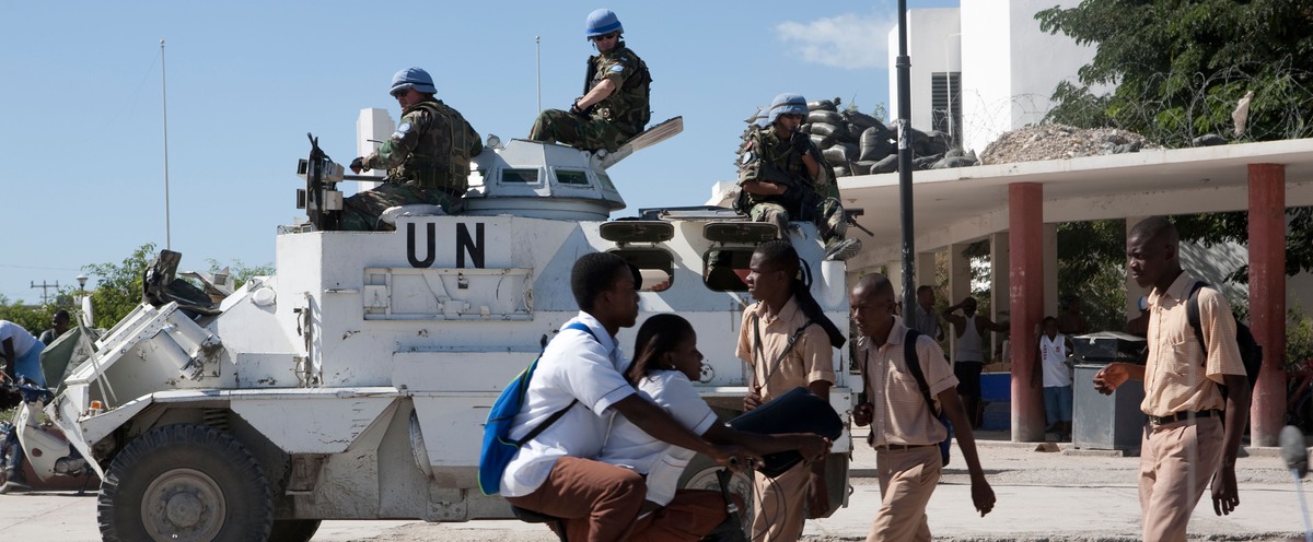 FN-patrull i vitt FN-fordon i en afrikansk stad eller by.