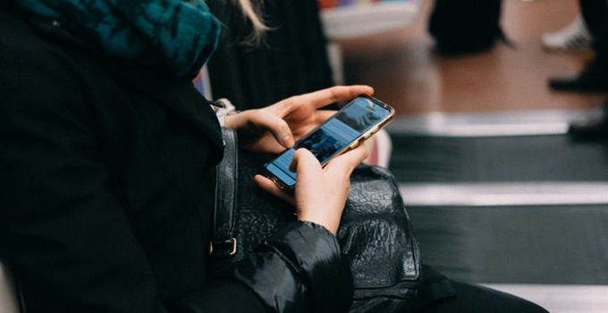 Närbild på hand som håller i en mobiltelefon. 