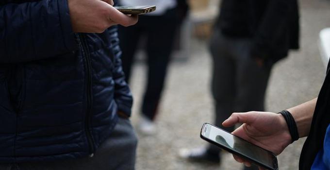 Händer som håller i mobiltelefon