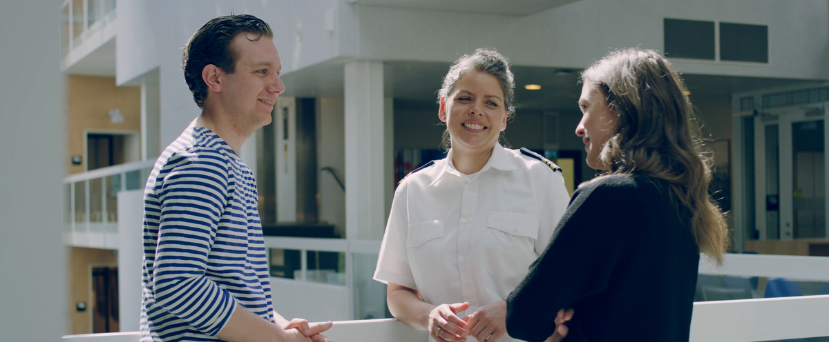 Civilian students in a conversation with a cadet.