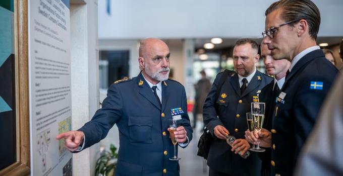 Militärer framför en poster.