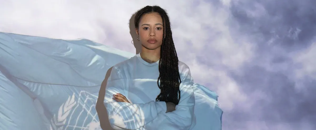 A woman in front of the UN flag.