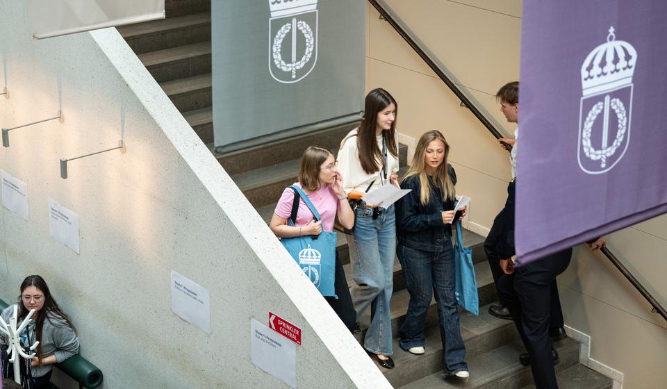 Studenter i trappan i ljusgården på Försvarshögskolan.