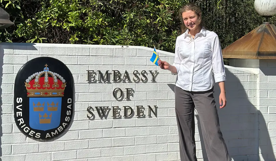 En kvinna som står framför en svenska ambassaden i Sydney.