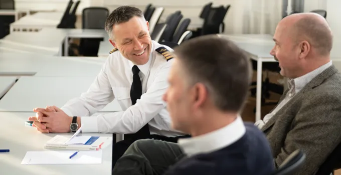 En grupp män som sitter runt ett bord och pratar.