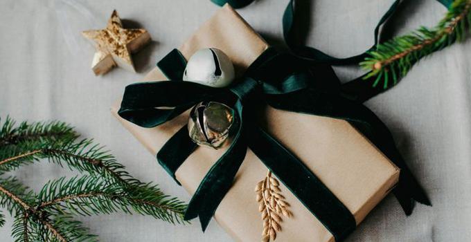 Inslagen bok med gröna band och grankvistar.