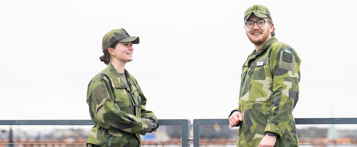 Två kadetter, en kvinna och en man, i kamouflagekläder på Försvarshögskolans tak.