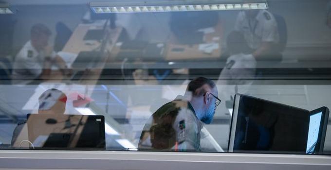 Bild på officerare framför datorer.