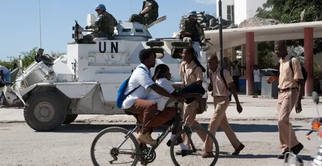 FN-patrull i afrikanskt land där civilbefolkningen rör sig på gatan.
