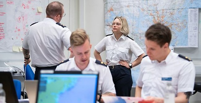 Personer i ett rum under pågående krigsspel. 
