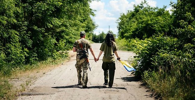 Ukrainska soldater håller varandra i handen