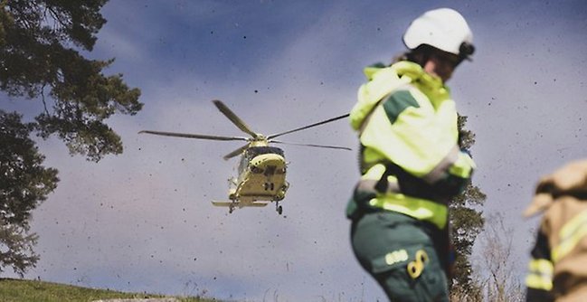 Ambulanspersonal och helikopter. 