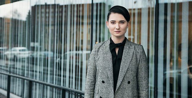 Student framför glasfasad