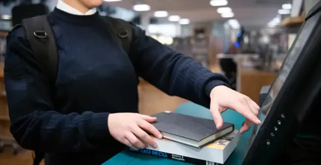 A woman standing at a counter with a book on it.