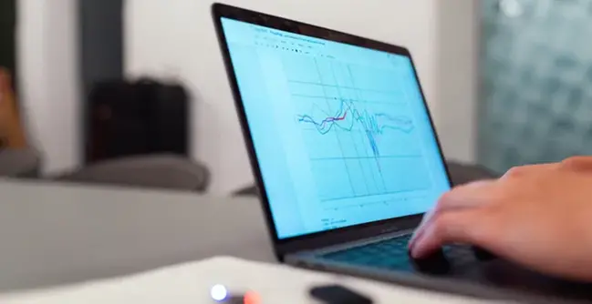 A person using a laptop computer on a desk.